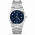 Tissot PRX watch with a stainless steel link bracelet, a silver-toned case, and a deep blue dial with a date window.